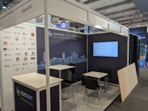 OpenHPC booth H40 at ISC 2026, showing the member logos panel, city skyline branding, and display screen, just hours before the exhibition opens